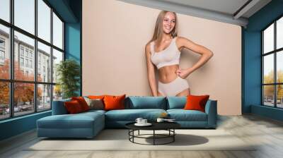 Young woman in underwear on beige background. Fitness, diet, skin and body care Wall mural